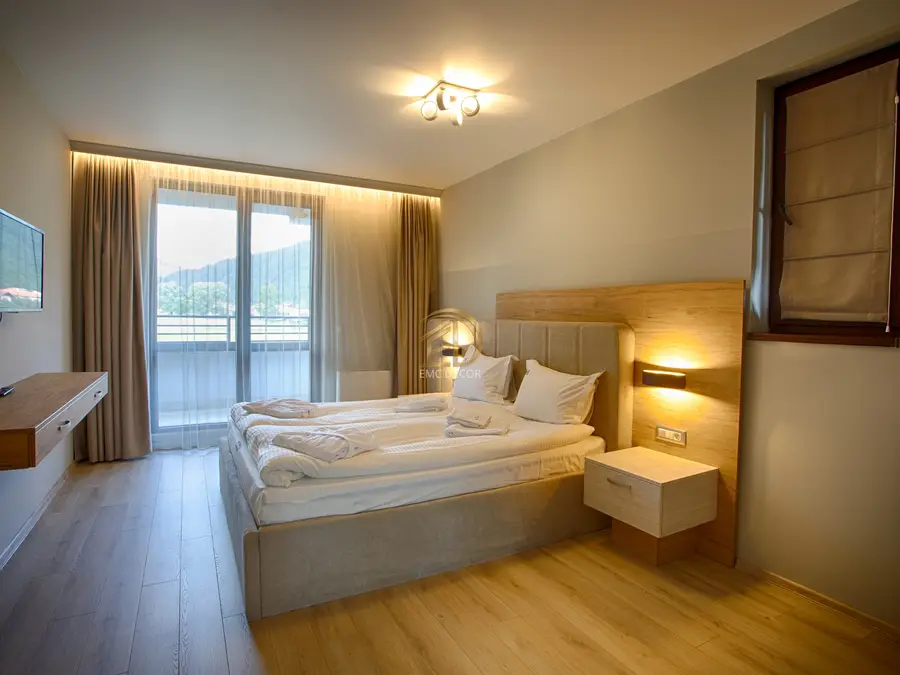 Balkonlu butik otel çift kişilik oda ahşap panel başlık ve sıcak LED aydınlatması